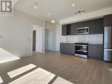 Toronto (Mount Pleasant West) condo for rent - A modern kitchen with dark brown cabinets and stainless steel appliances.