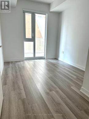 Toronto (Kensington-Chinatown) condo for rent - A room with a wooden floor and a sliding glass door.
