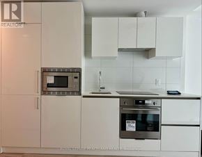 Toronto (Kensington-Chinatown) condo for rent - A kitchen with white cabinets and a stainless steel oven.