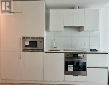 Toronto (Kensington-Chinatown) condo for rent - A kitchen with white cabinets and a stainless steel oven.