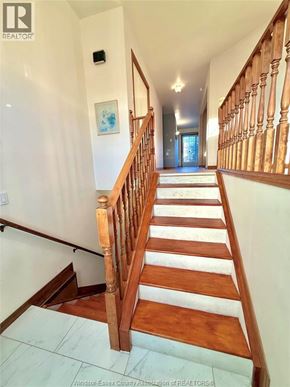 Windsor apartment for rent - A wooden staircase with a white landing.