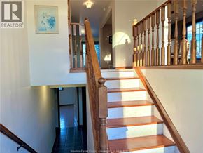 Windsor apartment for rent - A wooden staircase with a white wall and a painting on the wall.