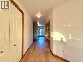 Windsor apartment for rent - A hallway with a wooden floor and white walls leading to a door.
