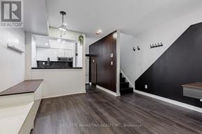 Toronto (Willowdale East) townhouse for rent - A modern kitchen with dark wood floors and a staircase leading to the upper level.
