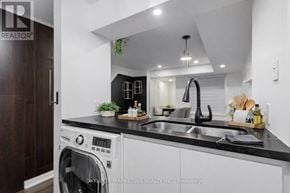 Toronto (Willowdale East) townhouse for rent - A modern kitchen with a washing machine and a black countertop.