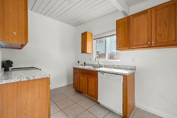 Richmond apartment for rent - A kitchen with wooden cabinets and a white dishwasher.