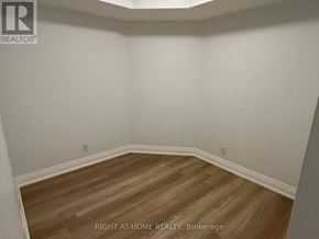 Markham (Unionville) condo for rent - A room with wooden flooring and white walls.