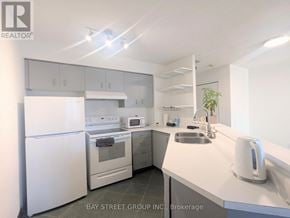 Toronto (Bay Street Corridor) condo for rent - A white kitchen with a refrigerator, oven, sink, and microwave.