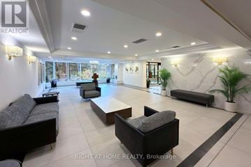 Brampton (Queen Street Corridor) condo for rent - A spacious living room with a black couch and a coffee table.