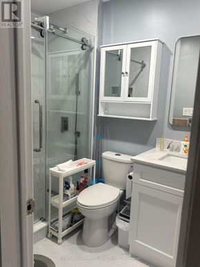 Toronto (Pleasant View) apartment for rent - A white toilet with a white cabinet and a glass shower stall.