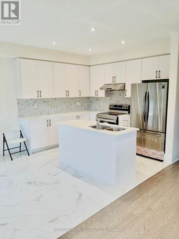 Brampton (Credit Valley) townhouse for rent - A modern kitchen with white cabinets and a marble floor.