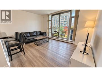 Vancouver apartment for rent - A living room with a black leather couch and a wooden floor.
