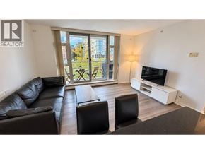 Vancouver apartment for rent - A living room with a black couch, a black chair, a wooden coffee table, and a flat screen TV.