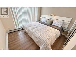 Vancouver apartment for rent - A bedroom with a bed, pillows, and a window with blinds.