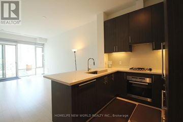 Toronto (Waterfront Communities) condo for rent - A kitchen with dark brown cabinets and a white counter top.