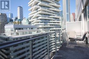 Toronto (Waterfront Communities) condo for rent - A balcony with a metal railing overlooks a cityscape.