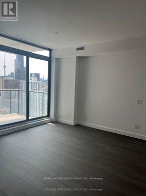 Toronto (Church-Yonge Corridor) condo for rent - A room with a view of the city skyline through a large window.