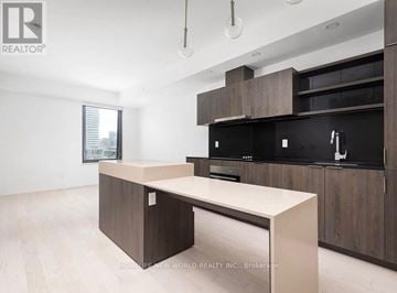 Toronto (Waterfront Communities) condo for rent - A modern kitchen with a large island in the middle.