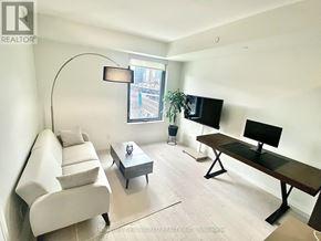 Toronto (Waterfront Communities) condo for rent - A living room with a white couch, a black table, and a window with a view of a city.