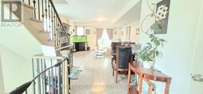 Oshawa (Windfields) townhouse for rent - A living room with a couch, a television, and a dining table.