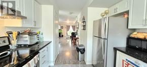 Oshawa (Windfields) townhouse for rent - A kitchen with black countertops and white cabinets.