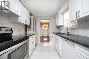 Milton (Tm Timberlea) apartment for rent - A kitchen with white cabinets and black countertops.