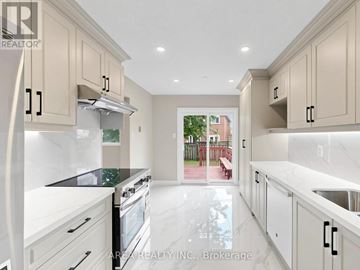 Mississauga (Hurontario) apartment for rent - A modern kitchen with white cabinets and black countertops.