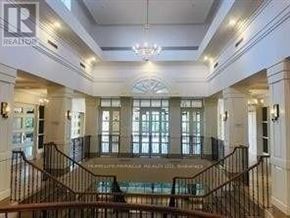 Toronto (West Humber-Clairville) condo for rent - A grand staircase with a black railing leads to a brightly lit upper level.