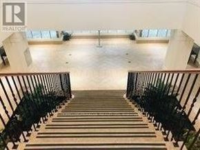 Toronto (West Humber-Clairville) condo for rent - A staircase with a metal railing leads to a brightly lit open space.