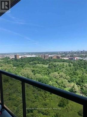 Toronto (West Humber-Clairville) condo for rent - A balcony overlooks a lush green forest and a city skyline.
