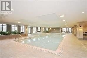 Toronto (West Humber-Clairville) condo for rent - A large indoor swimming pool with a tiled floor and a glass wall.