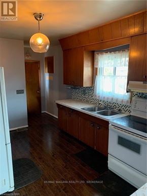 Welland (Welland Downtown) apartment for rent - A kitchen with wooden cabinets and a white fridge.