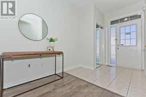 Milton (Cl Clarke) townhouse for rent - A room with a wooden table and a round mirror on the wall.
