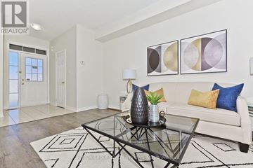 Milton (Cl Clarke) townhouse for rent - A living room with a glass coffee table and a couch with pillows.