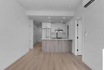 Surrey apartment for rent - A kitchen with white cabinets and a wooden island.