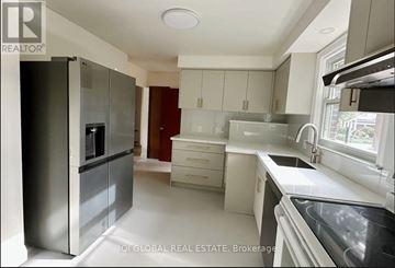 Richmond Hill (Harding) apartment for rent - A modern kitchen with white cabinets and a stainless steel refrigerator.
