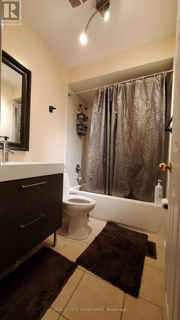 Toronto (Centennial Scarborough) townhouse for rent - A bathroom with a toilet, sink, and shower curtain.