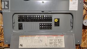 Toronto (Centennial Scarborough) townhouse for rent - A grey electrical panel with a yellow warning label and a Real Estate Home Warranty sticker.