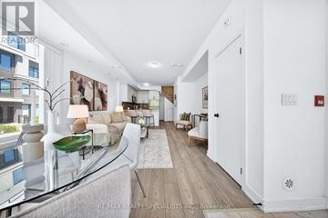 Mississauga (Erin Mills) townhouse for rent - A spacious living room with a long white couch and a glass table.