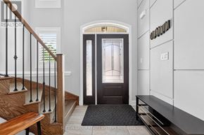 Oakville (Go Glenorchy) apartment for rent - A hallway with a wooden staircase and a black door.