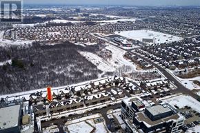 Oakville (Jm Joshua Meadows) townhouse for rent - A winter scene of a residential area with a road passing through.