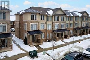 Oakville (Jm Joshua Meadows) townhouse for rent - A large building with a lot of windows and a car parked in front.