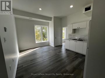 Centre Wellington (Elora/Salem) apartment for rent - A spacious kitchen with white cabinets and a window overlooking the trees.