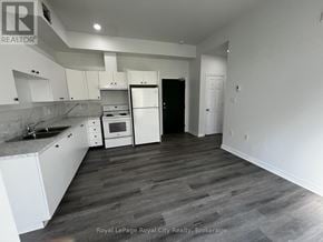 Centre Wellington (Elora/Salem) apartment for rent - A kitchen with white cabinets and a black refrigerator.