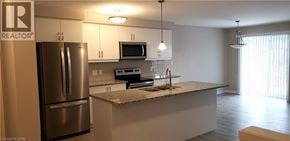 Kitchener townhouse for rent - A kitchen with a refrigerator, microwave, oven, and sink.