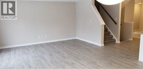 Kitchener townhouse for rent - A room with a staircase and a logo on the wall.