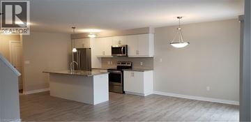 Kitchener townhouse for rent - A kitchen with white cabinets and a central island.