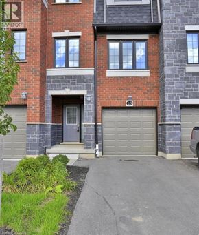 Kitchener townhouse for rent - A brick building with a garage door and a sign that says REALTOR.