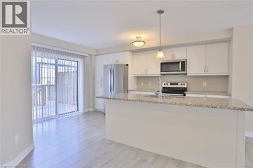 Kitchener townhouse for rent - A well-lit kitchen with a microwave, oven, and refrigerator.