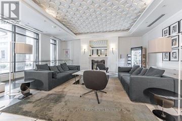 Toronto (Bay Street Corridor) condo for rent - A spacious living room with a grey sofa set and a wooden floor.